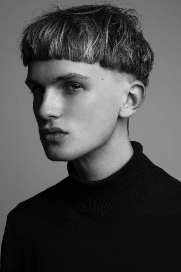 Black-and-white portrait: bowl haircut, serious expression.