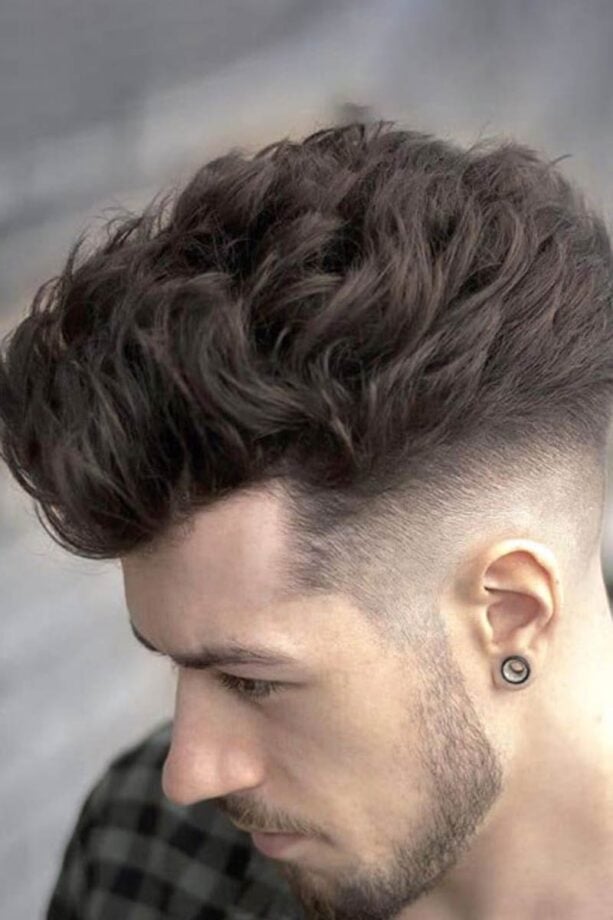 Person with high fade hairstyle and beard.