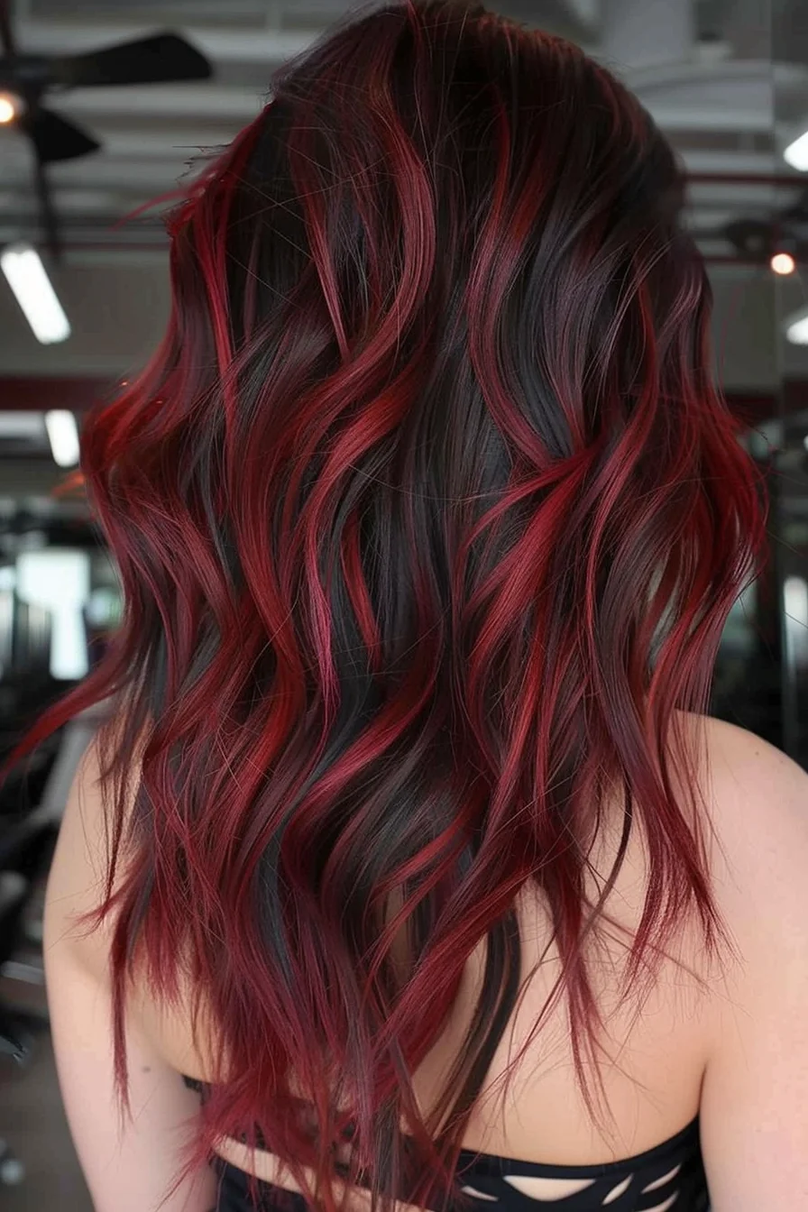 Deep espresso roots flow into vivid ruby-red pieces that brighten gradually through the lengths. Long layers styled in waves create natural movement, while painted highlights in varying shades of red add incredible depth. The color placement creates a stunning gradient effect that intensifies from roots to ends.