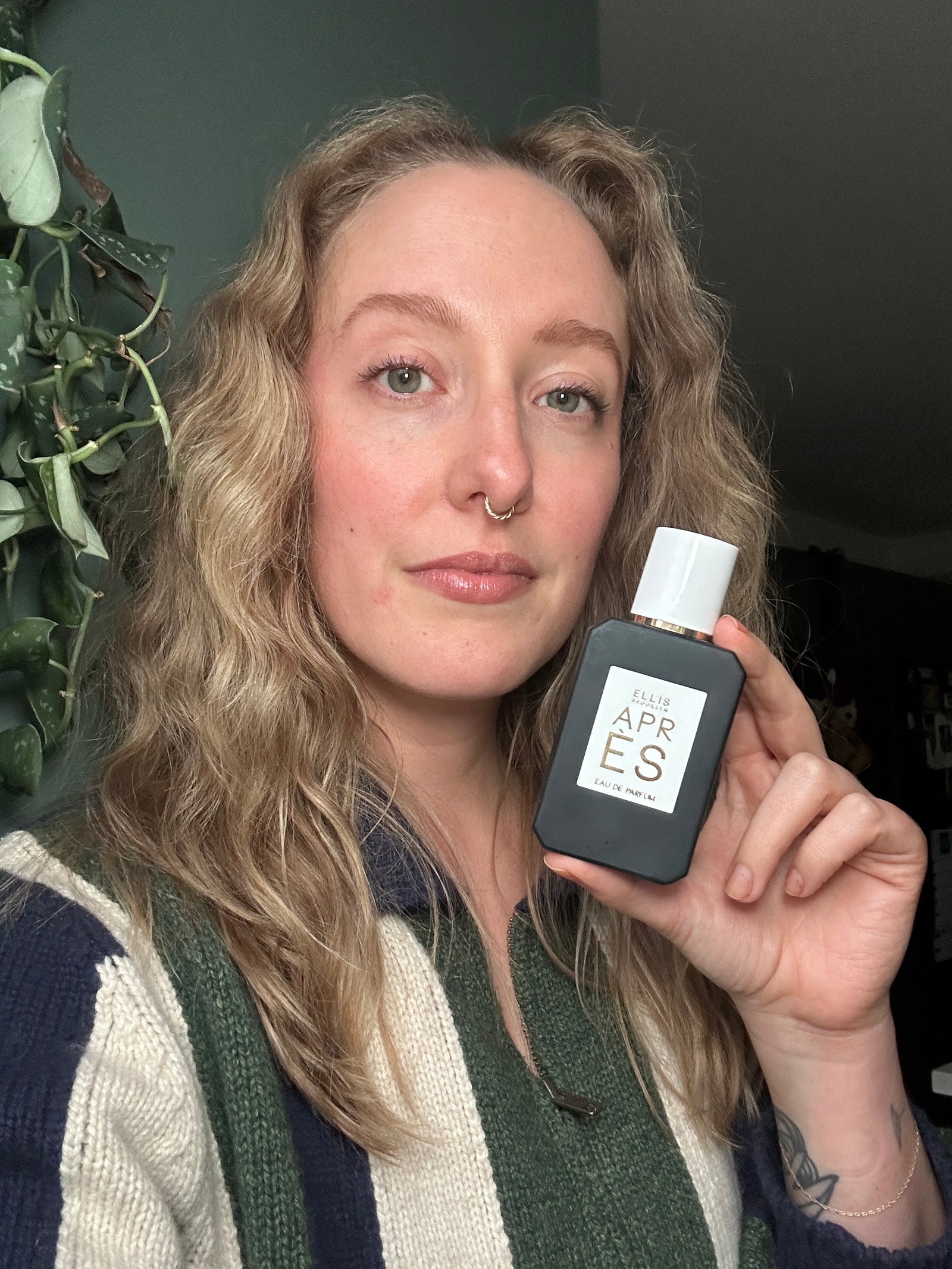 A selfie of Allure content director Kara McGrath holding a green bottle of Ellis Brooklyn Apres Eau de Parfum