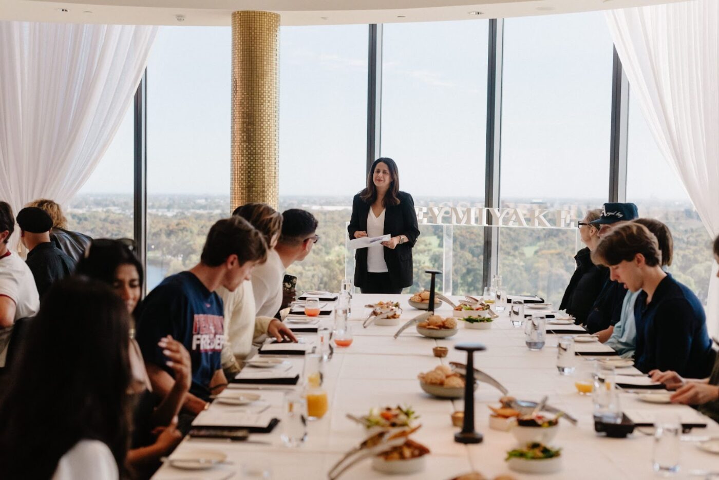 Woman leads meeting, Adelaide skyline.